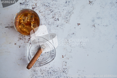 Image of Whiskey or brandy in a glass with Cuban cigar