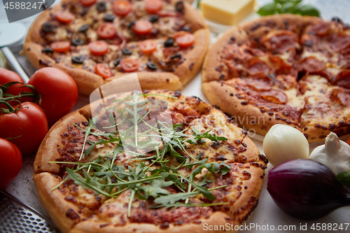 Image of Three american style pizzas served on a table