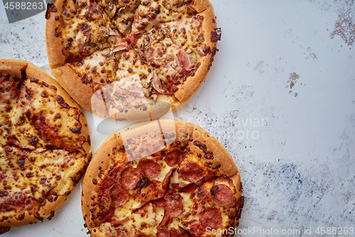 Image of Three american style pizzas served on a table