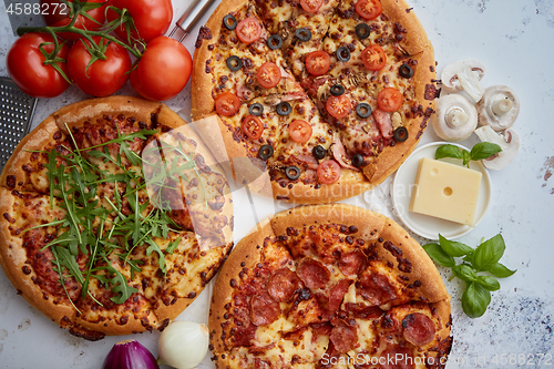 Image of Three american style pizzas served on a table