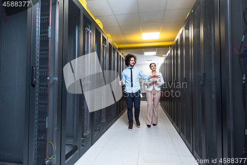 Image of engineer showing working data center server room to female chief