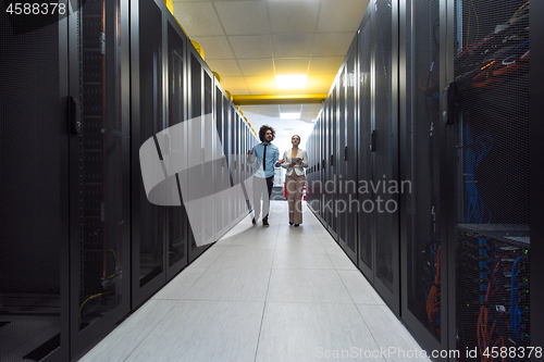 Image of engineer showing working data center server room to female chief