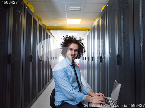 Image of engineer working on a laptop in server room