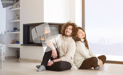 Image of happy multiethnic couple  in front of fireplace