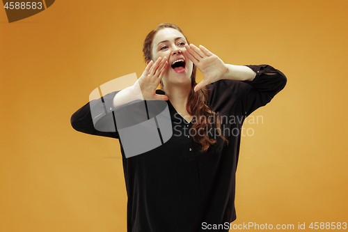 Image of Isolated on orange young casual woman shouting at studio