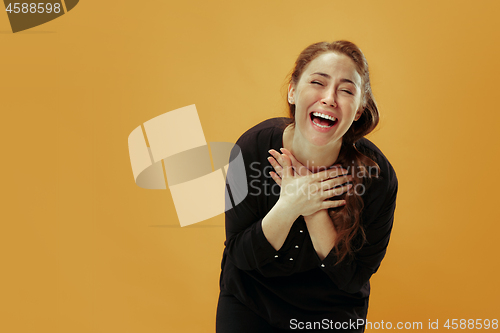 Image of The happy business woman standing and smiling against pastel background.