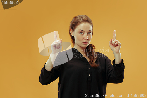 Image of Beautiful woman looking suprised isolated on gold
