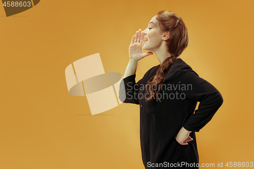 Image of Isolated on blue young casual woman shouting at studio