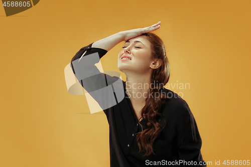 Image of Beautiful woman looking suprised and bewildered isolated on gold