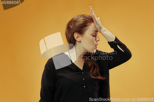 Image of Beautiful woman looking suprised and bewildered isolated on gold