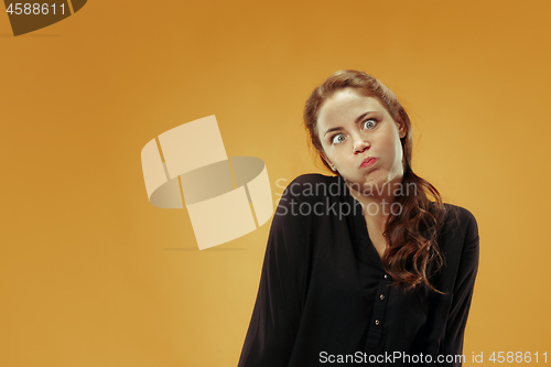 Image of The squint eyed woman with weird expression isolated on gold