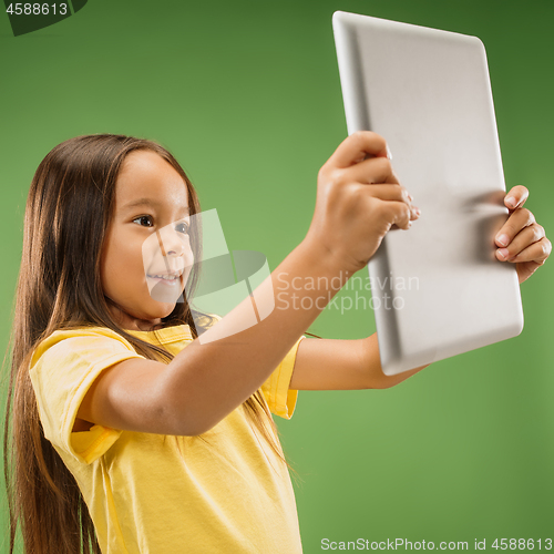 Image of Teen girl with laptop. Love to computer concept. Attractive female half-length front portrait, trendy green studio backgroud.