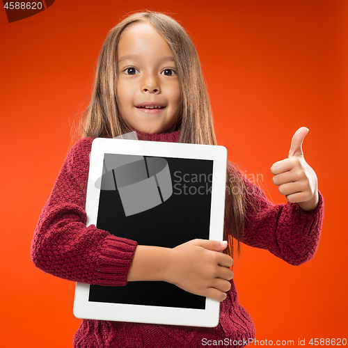 Image of Little funny girl with tablet on studio background