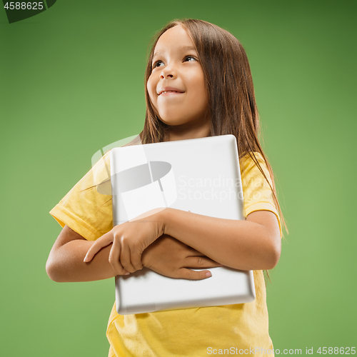 Image of Teen girl with laptop. Love to computer concept. Attractive female half-length front portrait, trendy green studio backgroud.