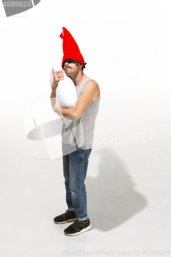 Image of Vertical shot of a content young man hugging a white pillow