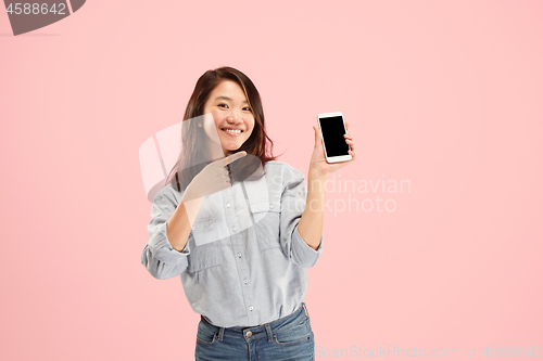 Image of Portrait of a confident casual girl showing blank screen mobile phone