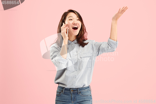 Image of Young beautiful woman using mobile phone studio on pink color background