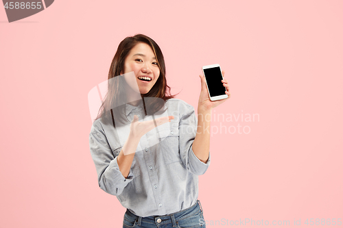Image of Portrait of a confident casual girl showing blank screen mobile phone