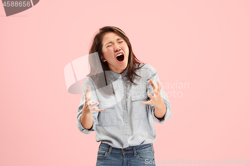 Image of The young emotional angry woman screaming on studio background