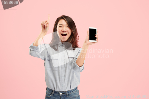 Image of Portrait of a confident casual girl showing blank screen mobile phone