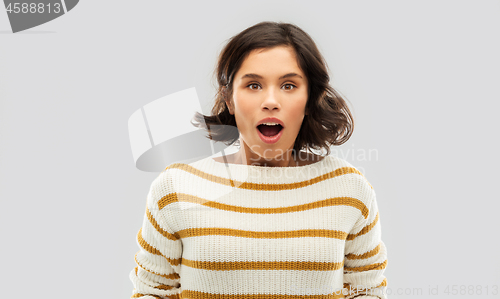 Image of surprised young woman in striped pullover