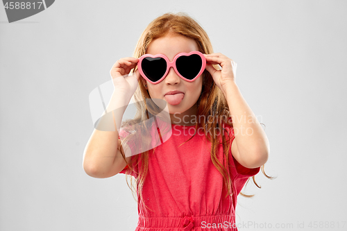 Image of naughty red haired girl in heart shaped sunglasses