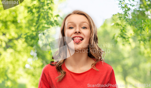 Image of funny teenage girl in red t-shirt showing tongue