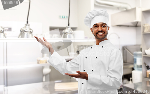 Image of happy male indian chef presents restaurant kitchen