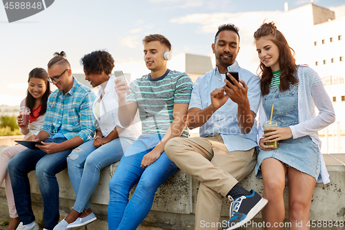 Image of friends with smartphones and tablet pc in city