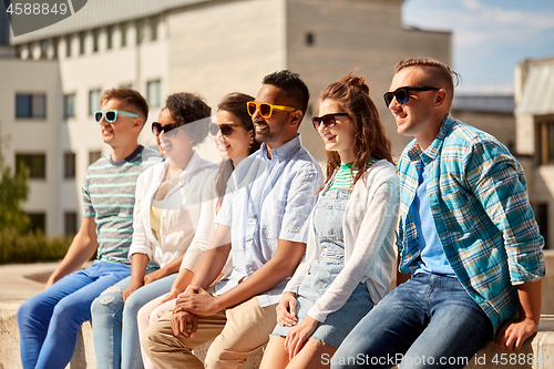 Image of happy friends in sunglasses at city in summer