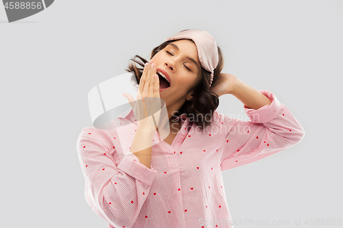 Image of happy young woman in pajama and eye sleeping mask