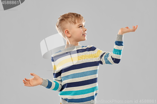 Image of smiling boy holding something on empty hands