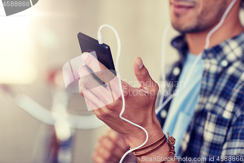 Image of man with earphones and smartphone listening music