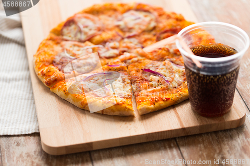 Image of close up of homemade pizza with cola on table