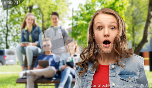 Image of surprised or shocked teenage girl over friends