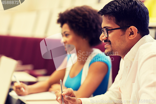 Image of group of students with notebooks in lecture hall