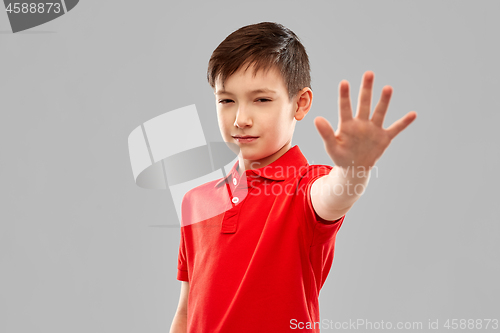 Image of boy in red t-shirt making stop gesture