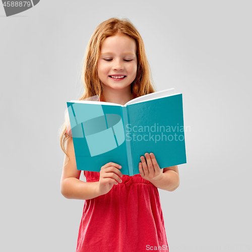 Image of smiling red haired girl reading book