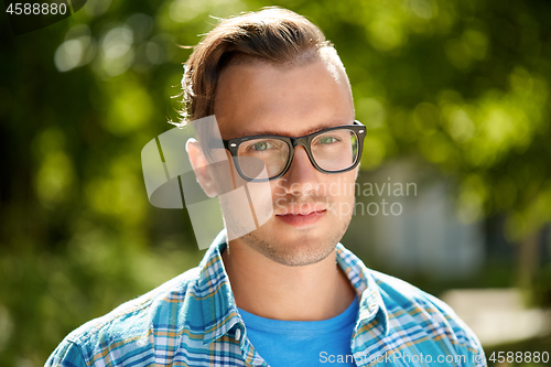 Image of portrait of young man in glasses outdoor in summer