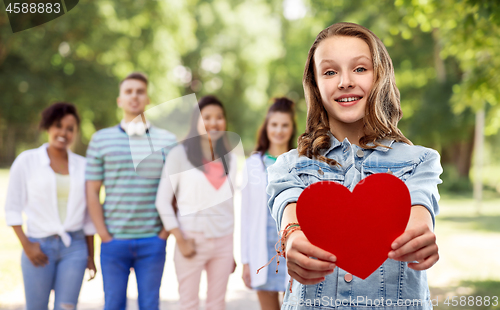 Image of smiling teenage girl with red heart outdoors