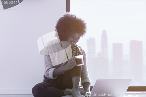 Image of black woman in the living room on the floor