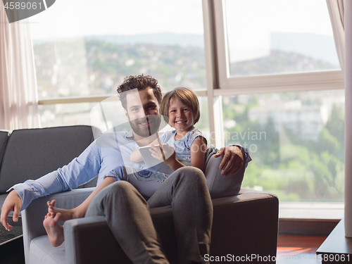 Image of girl and her handsome father using a digital tablet