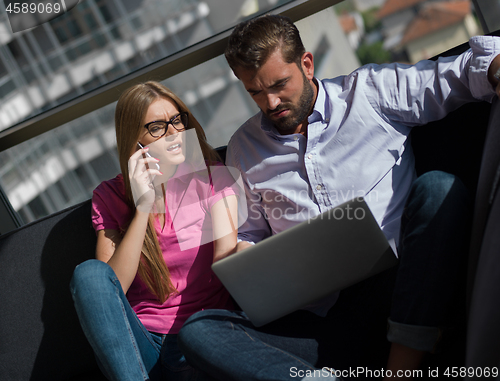 Image of couple relaxing at  home using laptop computer