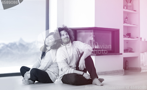 Image of happy multiethnic couple  in front of fireplace