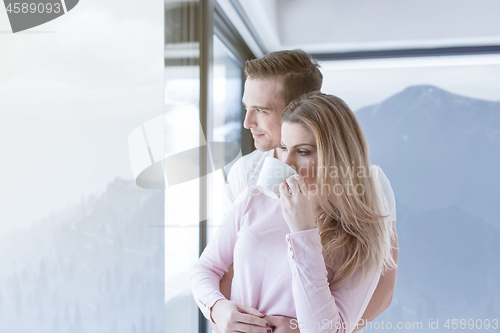 Image of young couple enjoying morning coffee by the window