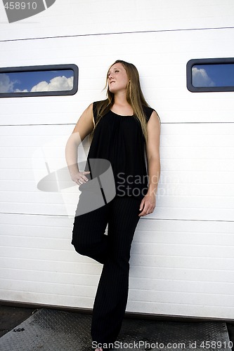 Image of Sexy girl posing by a shop door in the city