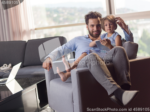 Image of girl and her handsome father using a digital tablet