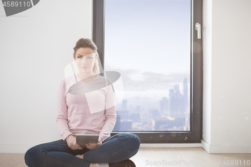 Image of woman using tablet computer with cats on snow in background