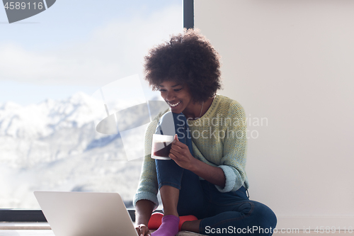 Image of black woman in the living room on the floor