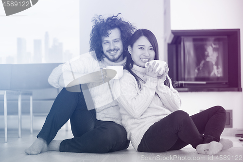 Image of happy multiethnic couple  in front of fireplace